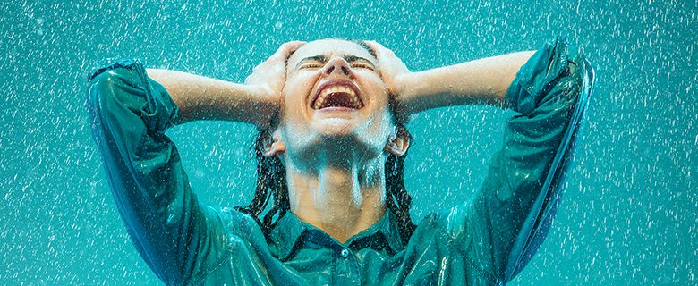 The portrait of young beautiful woman in the rain